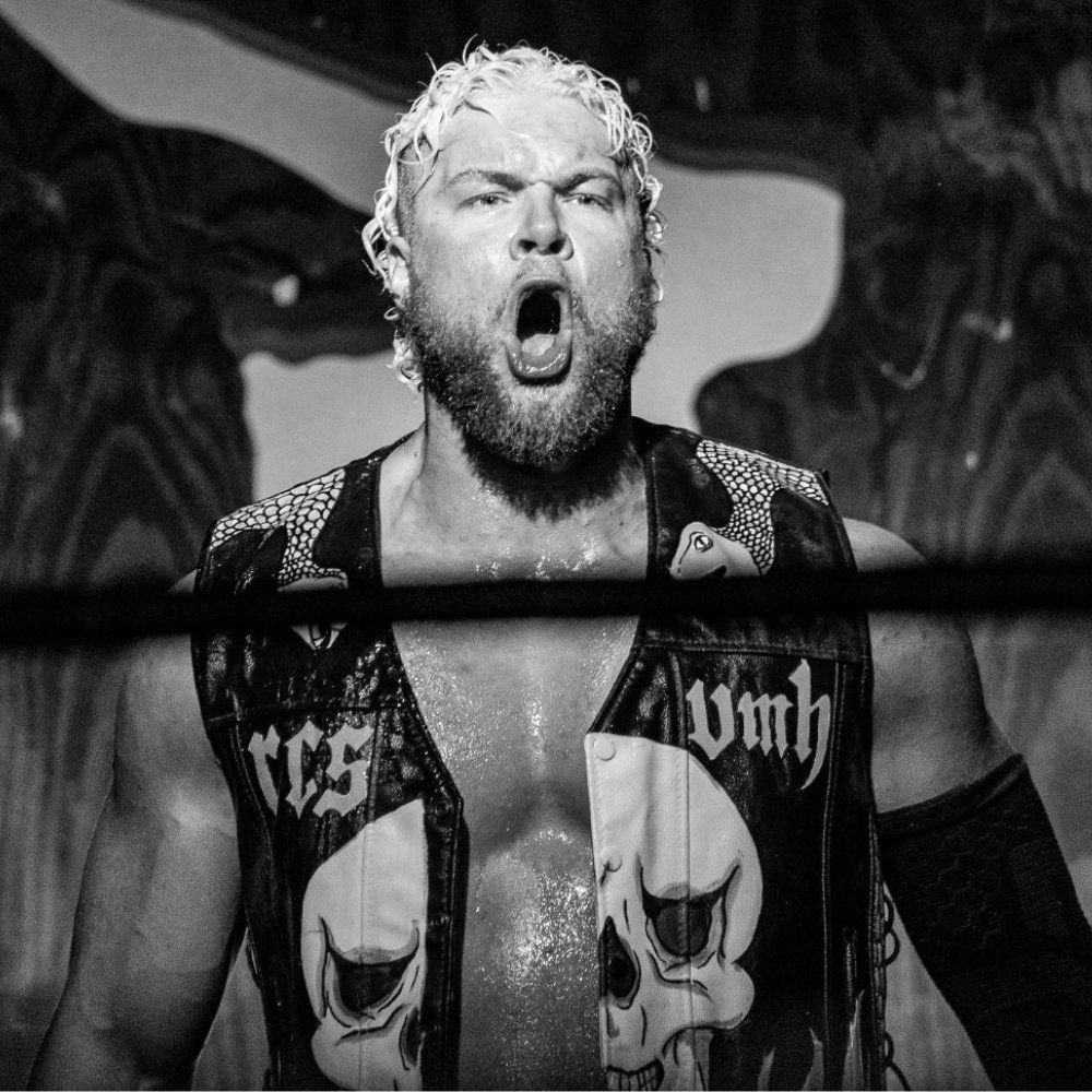 Josh Bishop yelling from the ring in a skull-painted leather vest